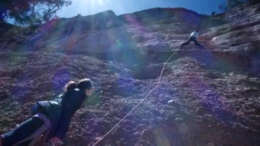 Arkadaşlar doğada kırmızı kayalara tırmanıyor. Yüksek kalite 4k görüntü