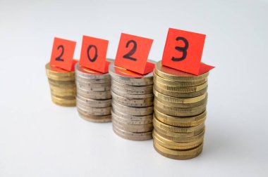 Yığınla bozuk para ve 2023 sayısını oluşturan kırmızı biletler. 2023 'ün gelişi ve yeni yıl umutları. 