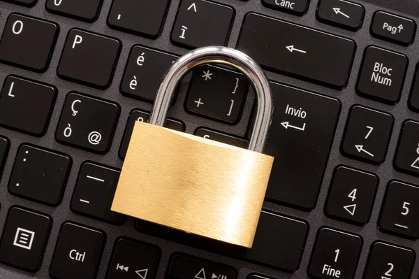 Closed padlock, placed above a pc keyboard. Protection of personal and sensitive data. Privacy.