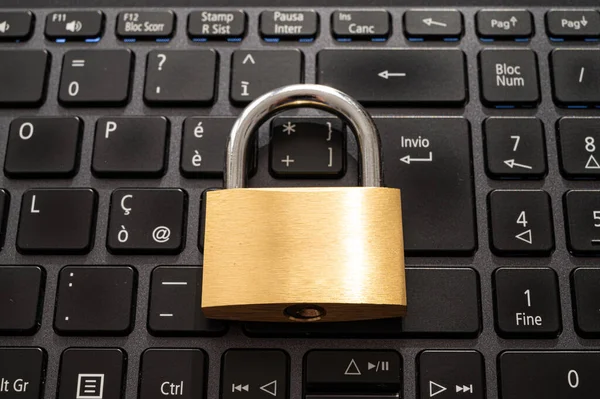 Closed padlock, placed above a pc keyboard. Protection of personal and sensitive data. Privacy.