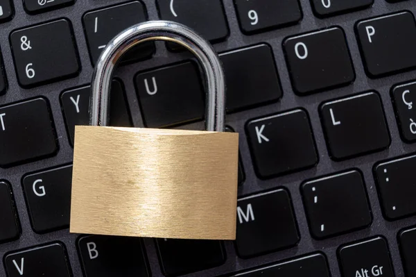 Closed padlock, placed above a pc keyboard. Protection of personal and sensitive data. Privacy.