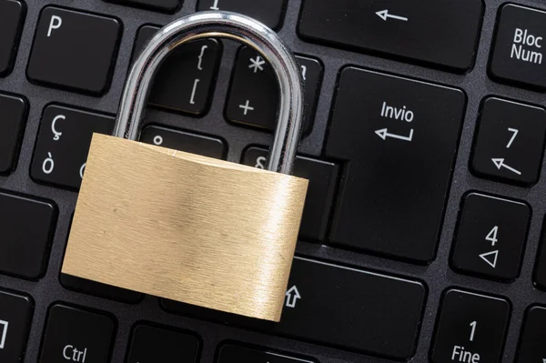 Closed padlock, placed above a pc keyboard. Protection of personal and sensitive data. Privacy.