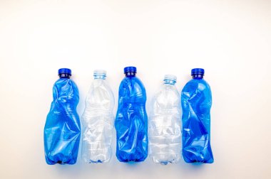 Plastic bottles, blue and transparent, crushed. Waste and plastic pollution, plastic recycling. 