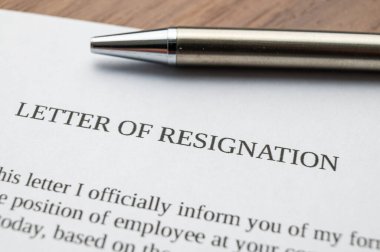 Employee resignation letter and pen beside. 