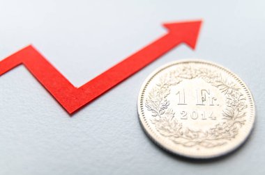 1 İsviçre Frangı madeni para, büyüme çizgisinin yanında. İsviçre Frangı 'nın değeri ve artan döviz kuru.