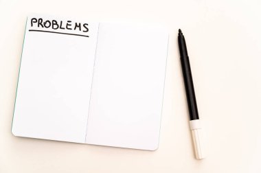 Boş defter sayfası, yanında yazım sorunları ve işaretleyici var. Sorunlar, çözümler ve cevaplar.