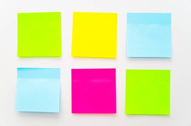 Beyaz bir yüzeye yapışmış çeşitli renklerde postala. Notlar ve notlar.