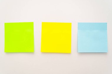 Beyaz bir yüzeye yapışmış çeşitli renklerde postala. Notlar ve notlar.