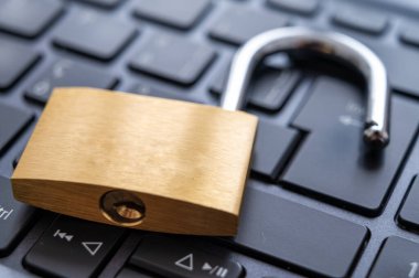 Bilgisayar klavyesinin üzerine yerleştirilmiş asma kilidi aç. Kişisel ve hassas verilerin korunması, izinsiz girme riski. Mahremiyet.