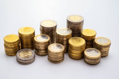Beyaz yüzeyde, para yığınları yan yana. Paranın miktarı, para birimi ve zenginlik.