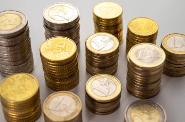 Beyaz yüzeyde, para yığınları yan yana. Paranın miktarı, para birimi ve zenginlik.