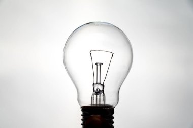 Yanan ampul, ışığa karşı çekilmiş, açık gibi görünüyor. Elektrik ve yenilenebilir enerji kaynakları.