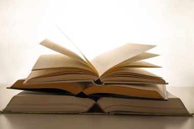 Açılmış kitap ve sayfalar, arka planda, beyaz arka planda. Okuma tutkusu.