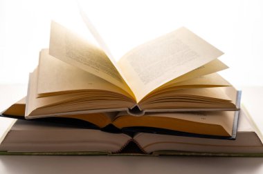 Açılmış kitap ve sayfalar, arka planda, beyaz arka planda. Okuma tutkusu.