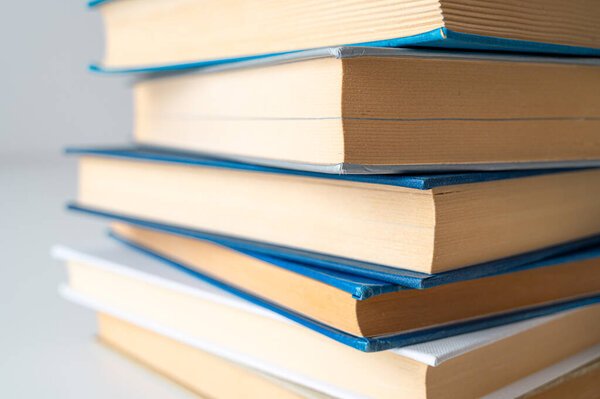 Стопка книг, сфотографированных близко, на белой поверхности.