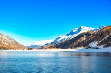 Motor, İsviçre, Sils Maria gölü, Isola köyü ve karlı manzara.