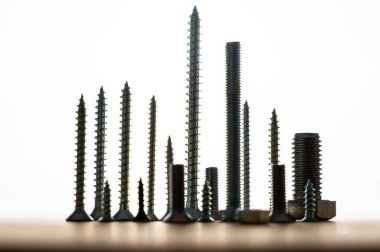 Metal vidalar birbirine yakın, yukarı bakıyor, arkadan aydınlatılıyor. Araçlar ve Araçlar.