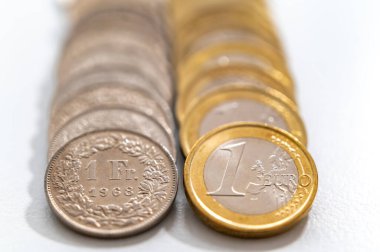 Beyaz yüzeyde Euro ve İsviçre Frangı paralar. İsviçre Frangı ve Euro 'nun değer ve döviz kuru. İsviçre Frangı CHF 'ye karşı.