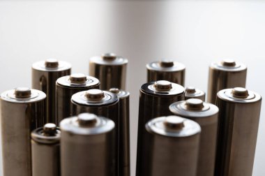 Bataryalar hafif bir yüzeyde yan yana dizildi. Piller, enerji ve çevreye saygı. Alkali ya da şarj edilebilir piller. 