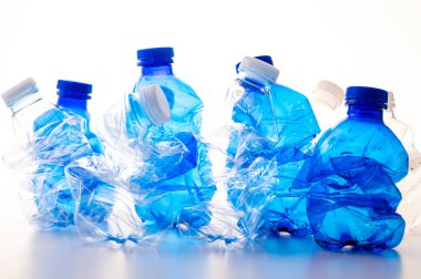 Plastic bottles, blue and transparent, crushed. Waste and plastic pollution, plastic recycling. 