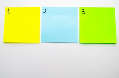 Birden üçe kadar numaralandırılmış renkli çıkartma kağıtları olan bir arka plan. Birinci, üçüncü.. 