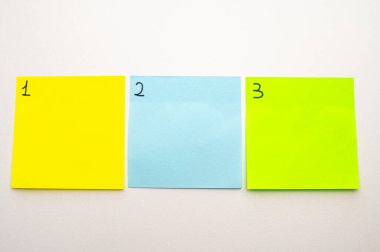 Birden üçe kadar numaralandırılmış renkli çıkartma kağıtları olan bir arka plan. Birinci, üçüncü.. 