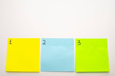 Birden üçe kadar numaralandırılmış renkli çıkartma kağıtları olan bir arka plan. Birinci, üçüncü.. 