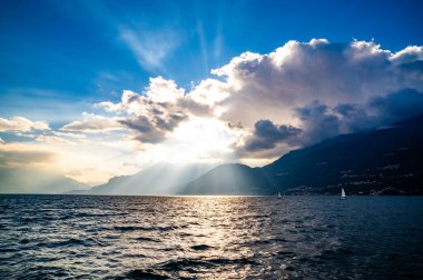 Dervio 'daki Como Gölü Panoraması' nda yelkenli tekneler ve güneş ışınları gölü aydınlatıyor..