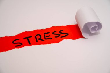 Red surface, with the word Stress in black, under torn and rolled white cardboard. clipart