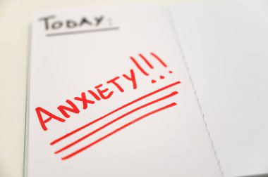 Blank journal page, with the word Anxiety in red. Anxiety and a request for help. clipart