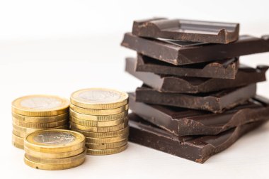Bozuk para yığınlarının yanına çikolata parçaları istiflenmiş. Çikolata fiyatlarına zam.