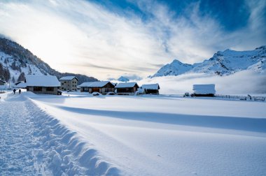 Engadine, Switzerland: Lake Sils Maria, the village of Isola, photographed in winter, with snow and the frozen lake. clipart