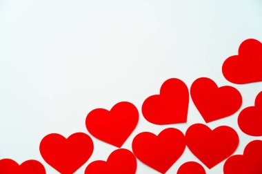 Kırmızı kalpler, beyaz bir yüzeyde yan yana. Aşk, duygular.