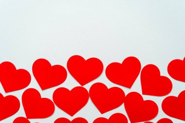 Kırmızı kalpler, beyaz bir yüzeyde yan yana. Aşk, duygular.
