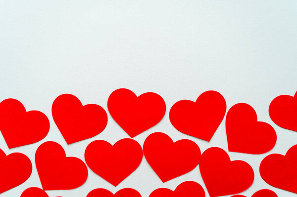 Красные сердца, рядом друг с другом, на белой поверхности. Любовь, чувства.