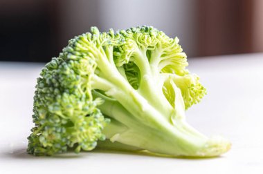 Broccoli, placed on white surface. Nutritional qualities and recipes. clipart