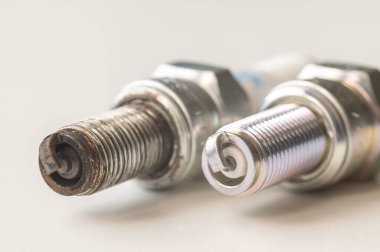 Beyaz yüzeydeki içten yanmalı motor için yeni ve kullanılmış bujiler. Bakım, bakım, motorun verimliliği.