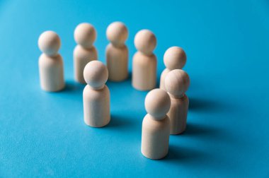 İş yerinde mafya, dışlanma ve psikolojik şiddet kavramı. Ahşap piyonlarla soyut bir tasvir, diğer insanlar tarafından hedef alınan bir kişinin..