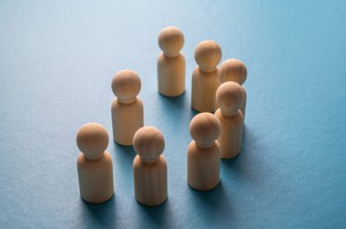 İş yerinde mafya, dışlanma ve psikolojik şiddet kavramı. Ahşap piyonlarla soyut bir tasvir, diğer insanlar tarafından hedef alınan bir kişinin..