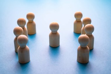 İş yerinde mafya, dışlanma ve psikolojik şiddet kavramı. Ahşap piyonlarla soyut bir tasvir, diğer insanlar tarafından hedef alınan bir kişinin..