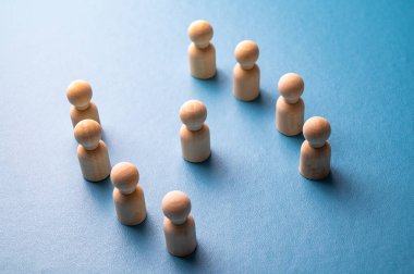 İş yerinde mafya, dışlanma ve psikolojik şiddet kavramı. Ahşap piyonlarla soyut bir tasvir, diğer insanlar tarafından hedef alınan bir kişinin..