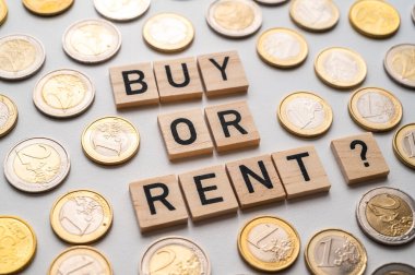 Tahta alfabeyle bestelenmiş bir metin al ya da kirala ve yanında beyaz bir arkaplanda madeni paralar olsun. Kiralama ve satın alma arasında seçim.