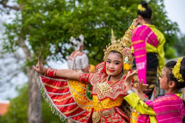 Genç geleneksel Tayland Dansçısı, Tayland 'ın Samut Songkhram kenti Amphawa şehrindeki Loy Krathong Festivali' nde Kasım 2022 'de düzenlenen bir gösteride.