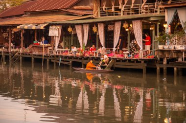Bir Budist keşiş, Tayland, Tayland, Amphawa 'da Samut Songkhram şehrindeki Mae Klong Nehri' nin Klong Chula 'sındaki bir orman teknesindeki evleri ziyaret ederek sadaka topluyor.