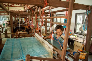 Kadınlar Tayland, Tayland, Ratchaburi 'deki Wat Muang Mon Çalışma Merkezi' nde dokuma Üretiminde çalışıyor. Kasım 2022