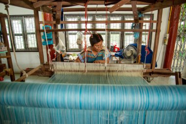 Kadınlar Tayland, Tayland, Ratchaburi 'deki Wat Muang Mon Çalışma Merkezi' nde dokuma Üretiminde çalışıyor. Kasım 2022