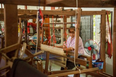 Kadınlar Tayland, Tayland, Ratchaburi 'deki Wat Muang Mon Çalışma Merkezi' nde dokuma Üretiminde çalışıyor. Kasım 2022