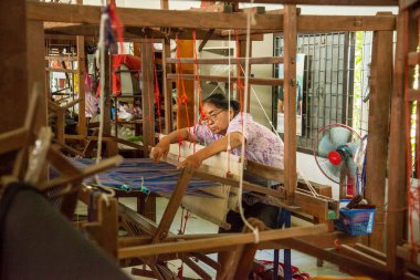 Kadınlar Tayland, Tayland, Ratchaburi 'deki Wat Muang Mon Çalışma Merkezi' nde dokuma Üretiminde çalışıyor. Kasım 2022