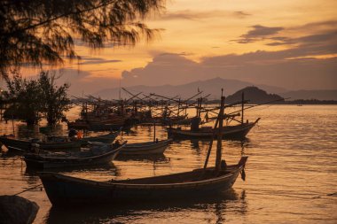 Tayland 'ın Prachuap Khiri Khan eyaletindeki Phrachuap Khiri Khan şehrindeki Khao Ta Mong Lai Orman Parkı' nda gün batımında balıkçı tekneleri, Tayland, Prachuap Khiri Han, Aralık 2022
