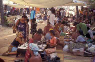 Hindistan, Hindistan, Goa, Nisan 1996 'da Anjuna şehrindeki Anjuna kasabasında eski tarz Anjuna bit pazarındaki dükkanlar ve turistler